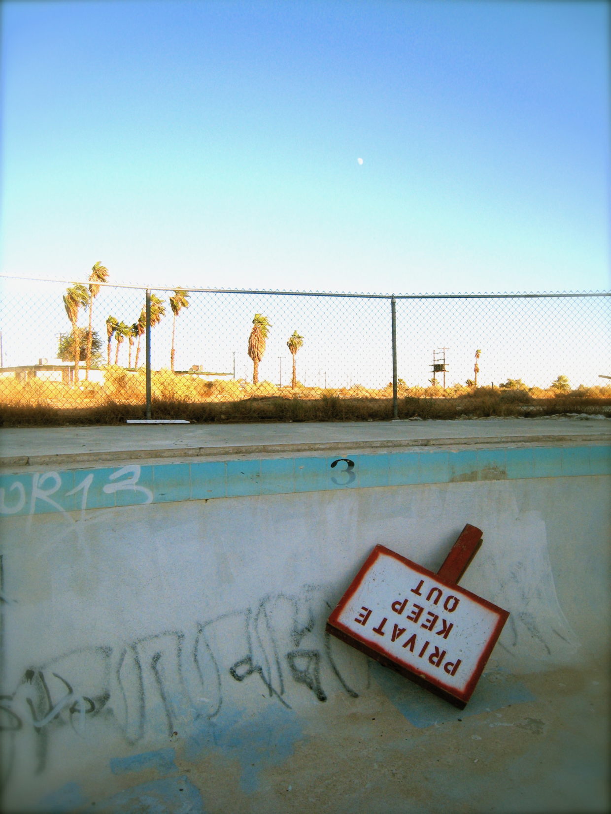 a Keep Out sign in an empty pool